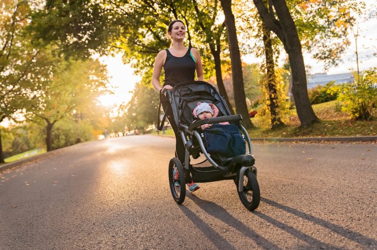 Fit mom pushing baby in running buggy