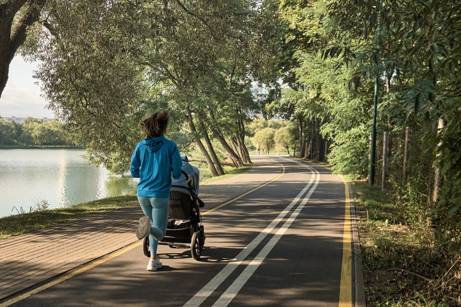 Woman jogging with baby in running stroller