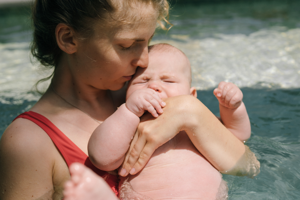 Young Mom swimming with baby in water