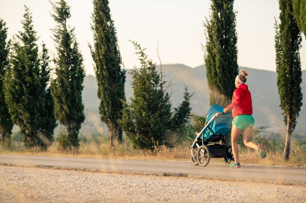 Active mom running with baby jogging stroller