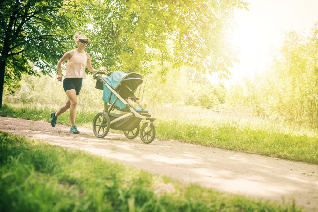 Fit woman running downhill with baby in stroller