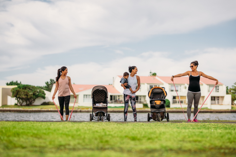 moms in the park exercising together with their babies in strollers