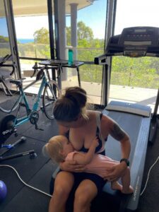 Clare Clark nursing her baby during a training session at home