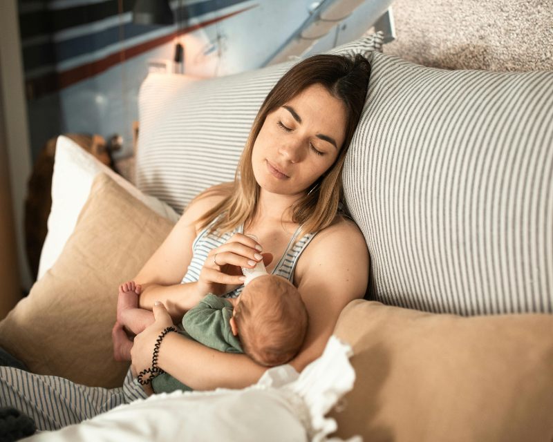mom with postpartum fatigue bottle feeding