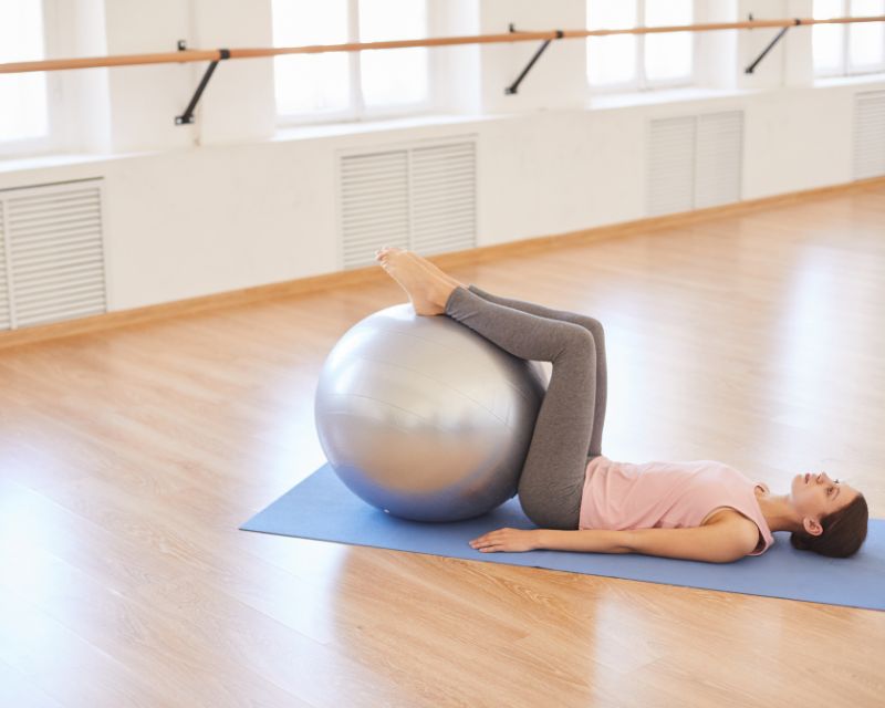 Woman performing effective post c section core exercises with a yoga ball