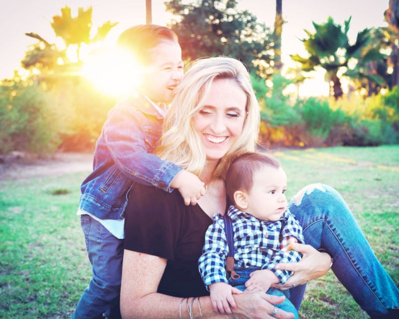 Happy mom bonding with kids before postpartum weight training.