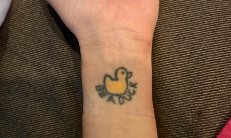 Mantra tattoo "Be a duck" on runner's wrist